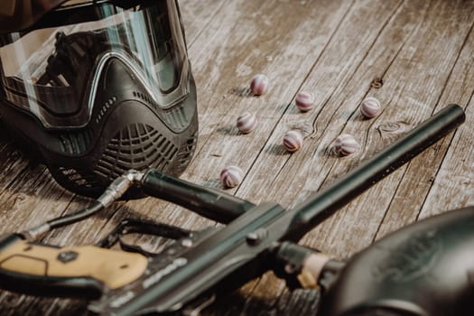 Close up of equipment for action paintball game, protective mask, gun and ball bullets, sport concept