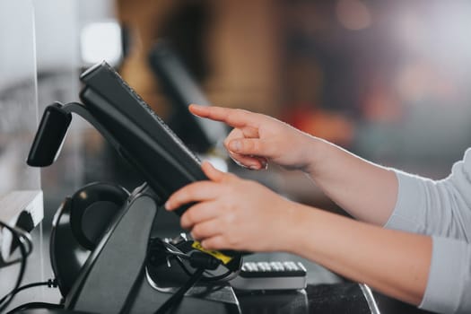 POS concept, young woman hand doing process payment on the touchscreen cash register, finance, shopping concept