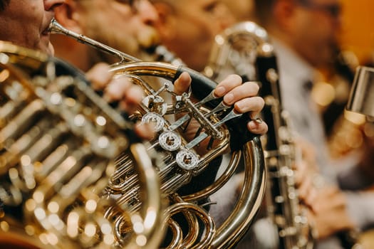 Close up of hand on a french horn during philharmonic concert, art concept