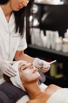 Shot of a beautiful young woman getting a facial mask treatment at the beauty salon.