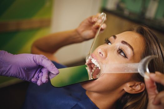 Shot of a beautiful young woman is at the dentist. She sits in the dentist's chair and the dentist checking aesthetic self-aligning lingual locks.