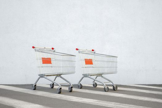 Two empty grocery cart shopping online store concept. Supermarket cart ecommerce shop. Double benefits concept shopping trolley supermarket. Empty trolley cart market store wall background sale design