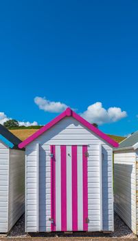 Colourful beach houses. Row of multicolored beach huts against blue sky.