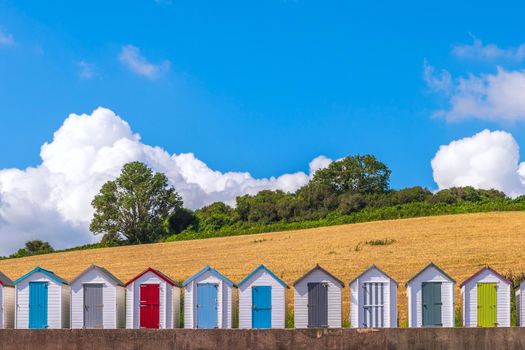 Colourful beach houses. Row of multicolored beach huts against blue sky.