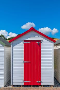 Colourful beach houses. Row of multicolored beach huts against blue sky.