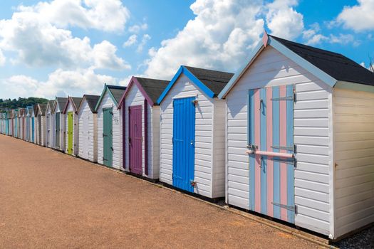 Colourful beach houses. Row of multicolored beach huts against blue sky.