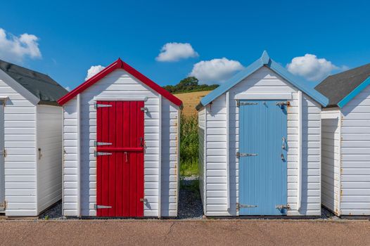 Colourful beach houses. Row of multicolored beach huts against blue sky.