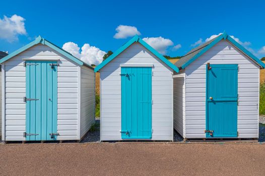 Colourful beach houses. Row of multicolored beach huts against blue sky.