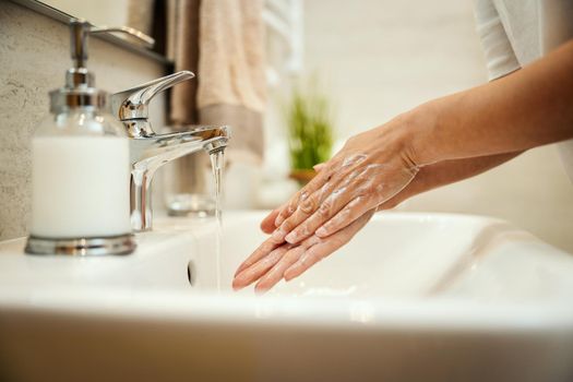 Closeup shot of an unrecognizable woman washing her hands with soap to prevent Coronavirus.