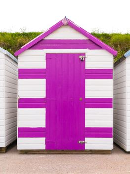 Colourful beach houses. Row of multicolored beach huts against blue sky.