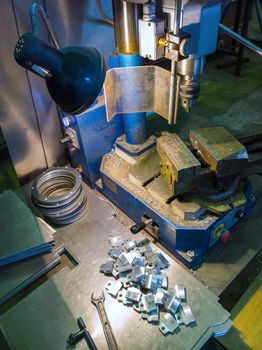 Drilling locksmith workplace with old dirty vertical drilling machine.