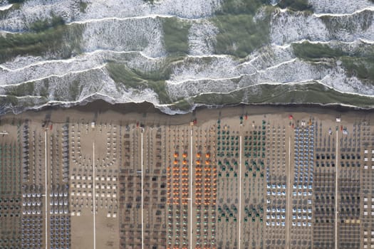 Aerial view of Versilia beach with rough sea photographed from above 