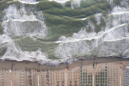 Aerial view of Versilia beach with rough sea photographed from above 