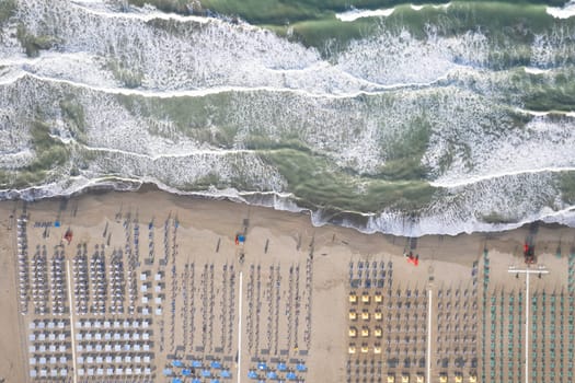 Aerial view of Versilia beach with rough sea photographed from above 