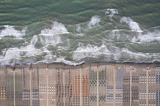 Aerial view of Versilia beach with rough sea photographed from above 