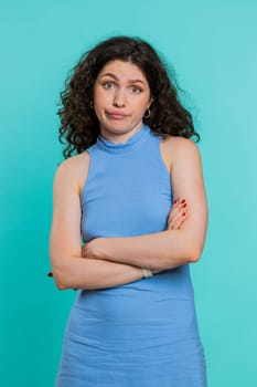 Offended sad nervous woman having misunderstanding, frustrated after quarrel, fail, lose, ignores and does not want to communicate, talk. Girl isolated on blue studio background. Lifestyles. Vertical