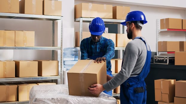 Young male workers checking merchandise in packages, using scanner to scan barcodes and send orders. Team of people planning business distribution with goods in cardboard boxes.