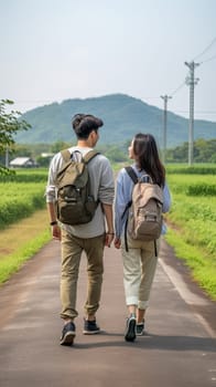 Couple of young Asian backpackers walking together looking each other in nature.