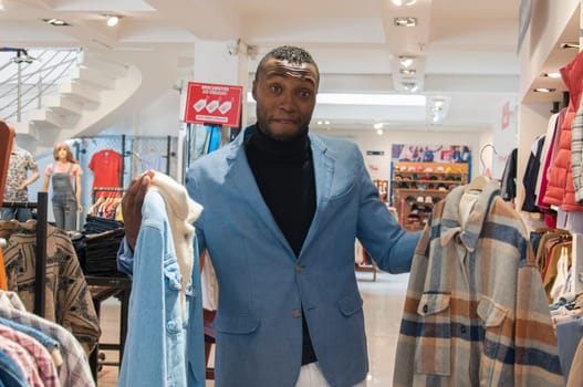 african man shopping for clothes in a mall for blackfriday. High quality photo