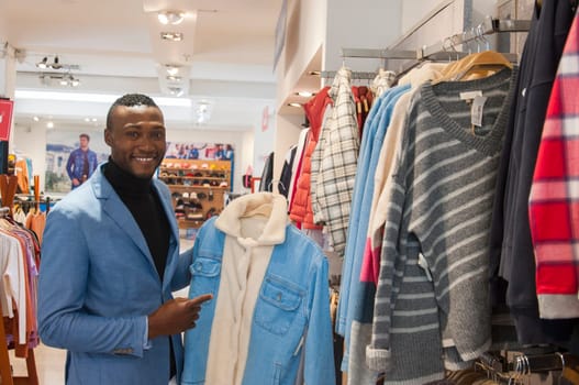 copyspace of a happy black man in a mall wearing a jacket smiling at camera. High quality photo