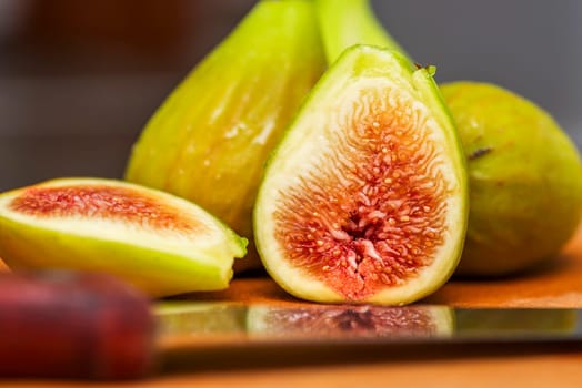 Ripe fresh figs on a wooden board with a knife. Ripe tasty figs.