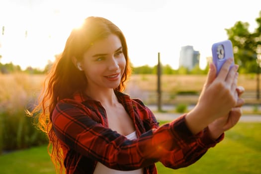 Portrait of a pretty girl taking a selfie at sunbeam.