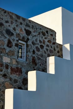 Greek architecture abstract background - whitewashed house with stairs and blue sky. Milos island, Greece