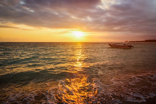 Calm ocean with boat during tropical sunrise