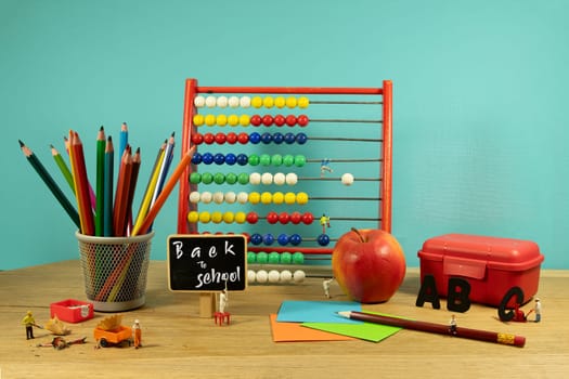 concept of back to school on blackboard for the start of a new school year with red apple lunchbox  pencils and abacus and pencil sharpener