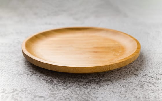 Wooden plate on a white stone background. handmade cooking utensils
