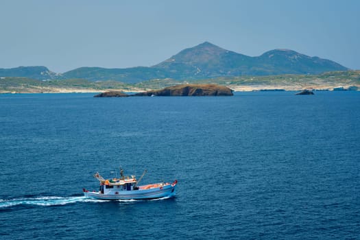 Greek fishing boat in blue waters of Aegean sea near Milos island, Greece