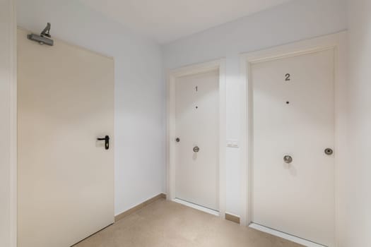 Hall space with two entrance doors to apartments or hotel rooms with the numbers one and two in white. The concept of a cozy compact five-star hotel.