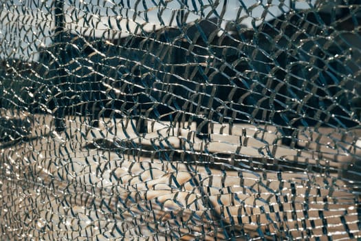 Abstract shot blurred summery city square through cracked broken glass. Conceptual avant-garde background for a website or landing page. Copyspace.