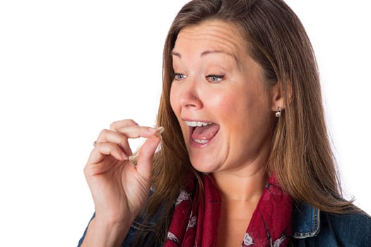 Forty year old woman, about to eat a pill, isolated on a white background