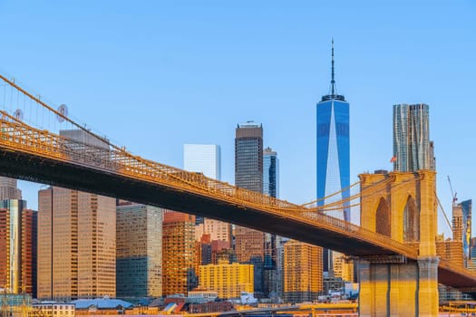 Manhattan's skyline with Brooklyn bridge, cityscape of New York City in the United States of America at sunrise