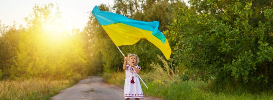 Child with the flag of Ukraine. Selective focus. Nature.