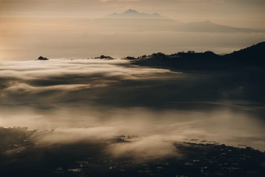 Early morning sunrise clouds at mountain Batur. Dawn mist covering volcano Batur