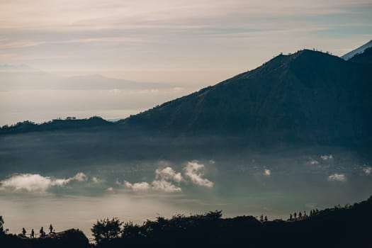 Mountain Batur landscape view in foggy morning. Volcano Batur silhouette with misty and cloudy sky