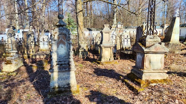 Sovetsk, Russia - April 03, 2023: Cemetery with old tombstones on sunny day in spring. Image with selective focus