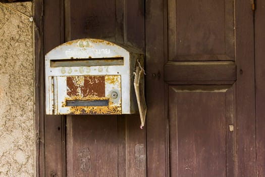 Old gray letter box on brown wood wall