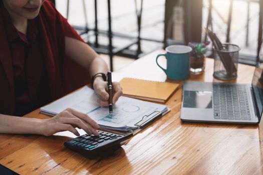 Close up on female hands making calculations. Young woman looking through financial report, managing monthly household expenses and incomes, using e-banking application, planning investments.