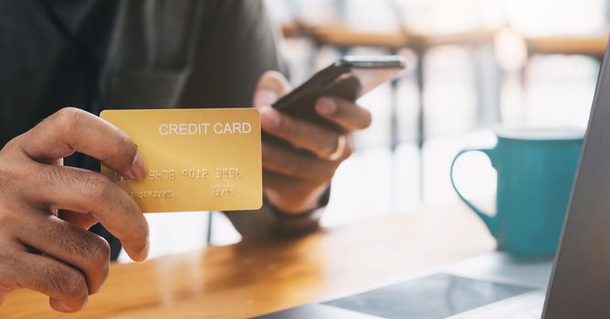 Online shopping concept, A man hands holding using mobile smart phone and credit card making online payment with smartphone.