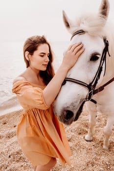 A white horse and a woman in a dress stand on a beach, with the sky and sea creating a picturesque backdrop for the scene