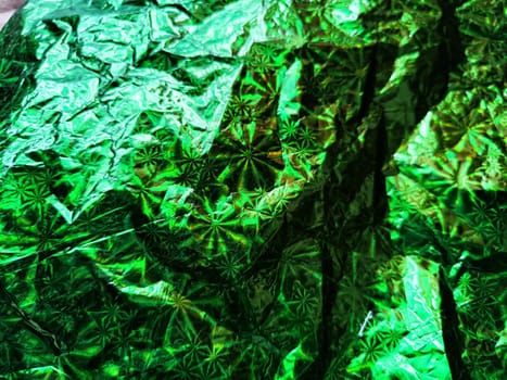 Beautiful abstract background and texture of crumpled aluminum foil in green color. Pattern, place for text and copy space