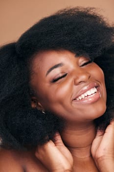 Smile, black woman and hair care for afro, beauty and cosmetics on a brown studio background. Growth, hairstyle or African model with makeup after natural treatment, texture or shine with wellness.