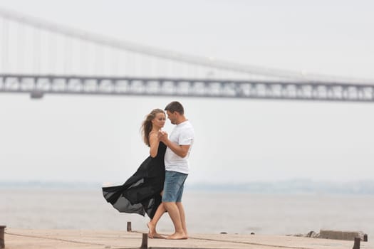A romantic married couple dancing on the pier. Mid shot