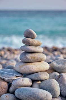 Zen meditation relaxation concept background - balanced stones stack close up on sea beach