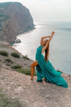 Woman sea trevel green dress. Side view a happy woman with long hair in a long mint dress posing on a beach with calm sea bokeh lights on sunny day. Girl on the nature on blue sky background