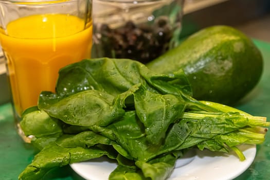 Green smoothie with spinach , mint, zucchini and cabbage as healthy summer drink isolated on wooden table.