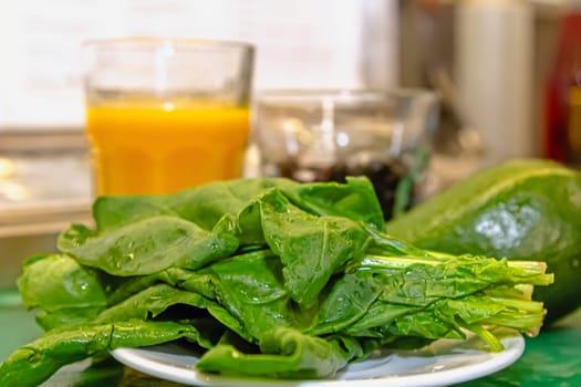 Green smoothie with spinach , mint, zucchini and cabbage as healthy summer drink isolated on wooden table.